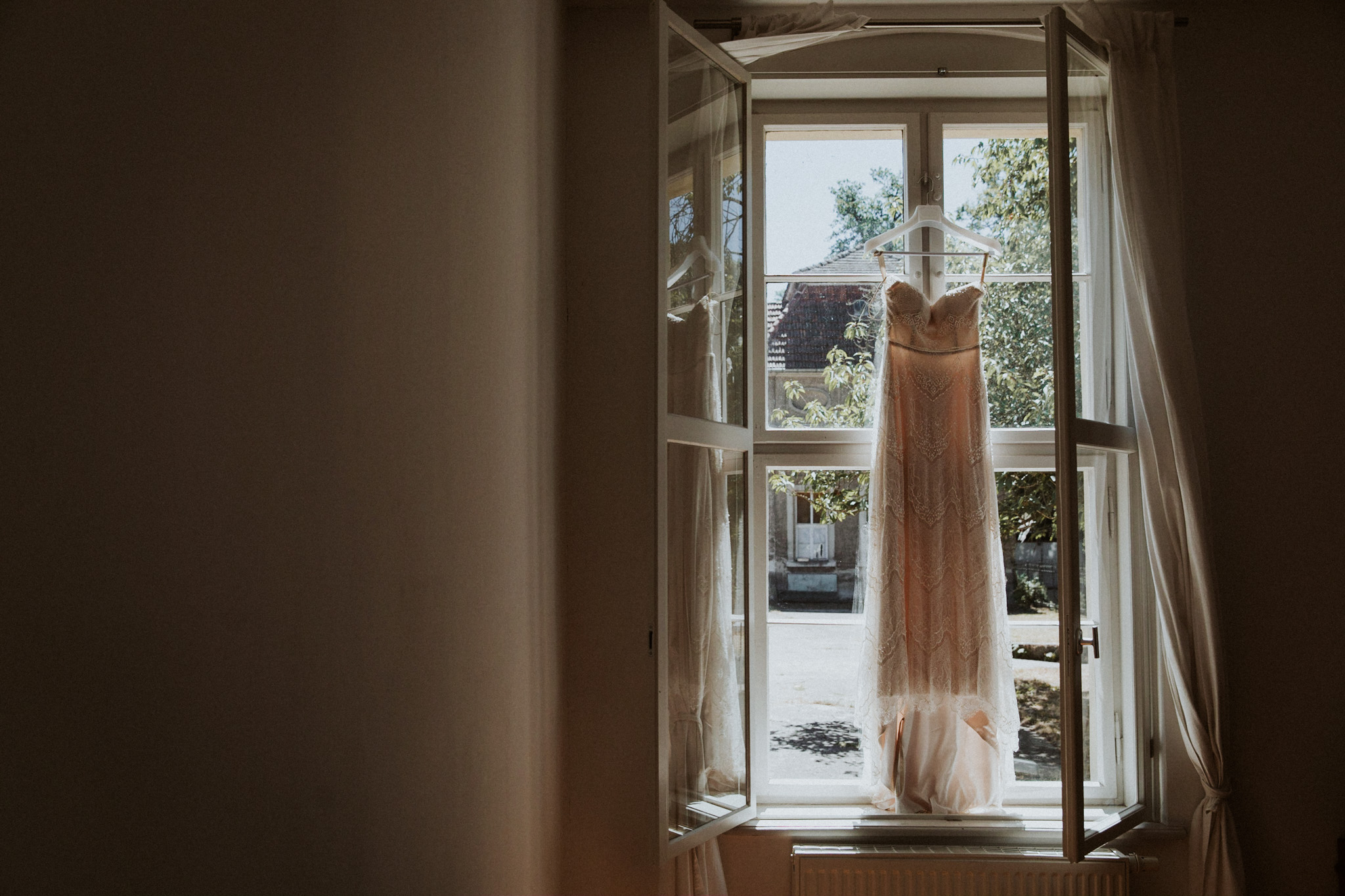 Ein Hochzeitskleid ist in einem Fenster bei einer Hochzeit auf Schloss Plaue