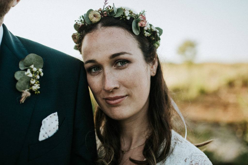 Braut mit buntem Blumenkranz bei einem Shooting